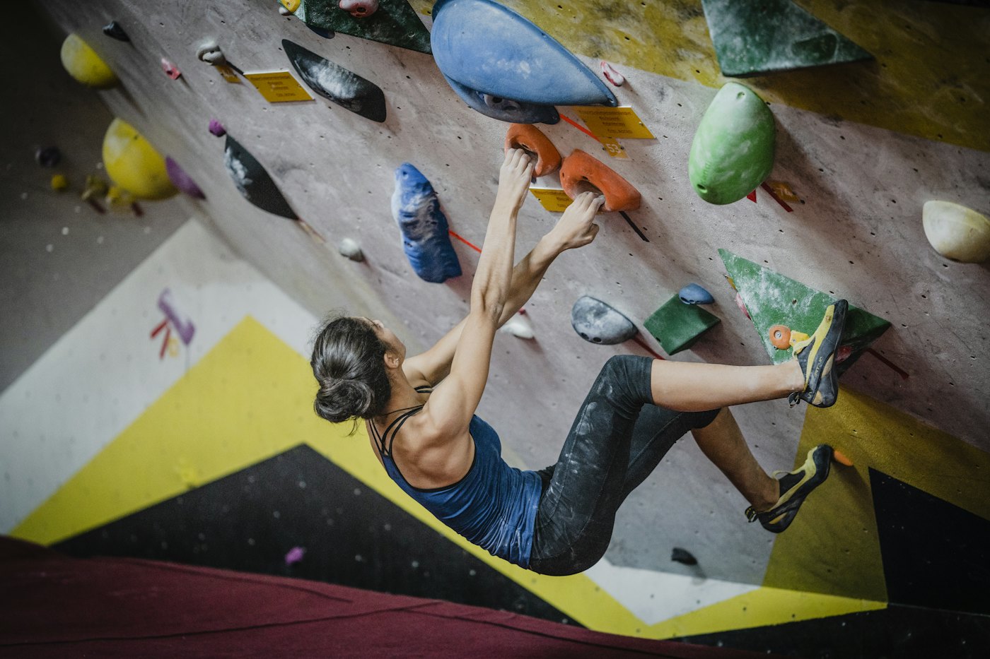 Escaladora en un bloque desplomado de un rocódromo