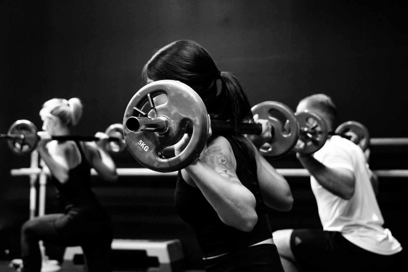 Clase dirigida con barras en un gimnasio